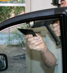 Paolo mentre monta una pellicola trasparente sul vetro di un'auto